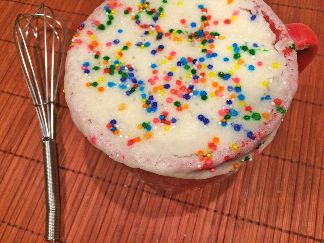 Simple Mug Cake with white cake and sprinkles in an oversized mug.
