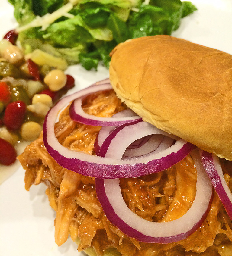 Barbecue Chicken Sandwich on hamburger bun with red onions.