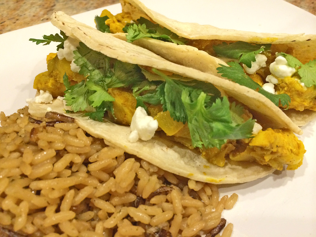 Chicken and pear tacos topped with goat cheese and cilantro with rice.