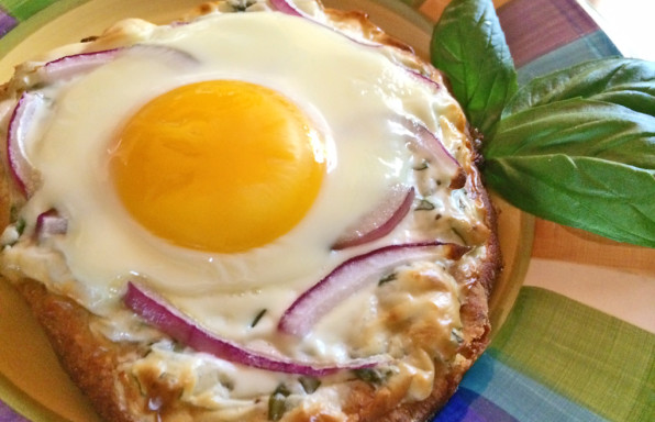 Homemade Breakfast Pizza with eggs, basil, and cream cheese.