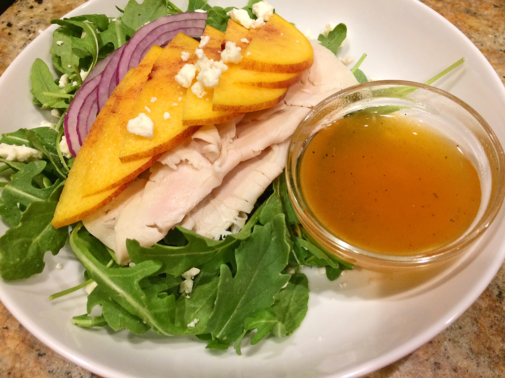 Arugula Salad with Ginger Peach Vinaigrette with turkey, peaches, and red onions.